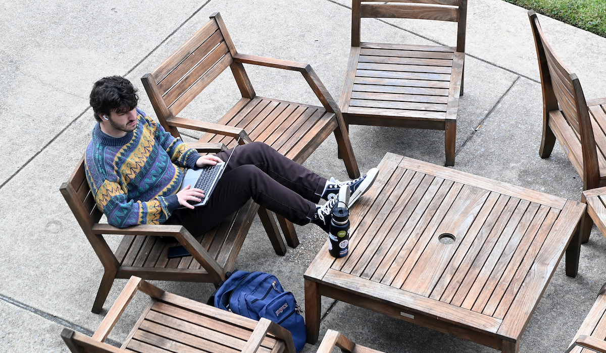 student on laptop outdoors